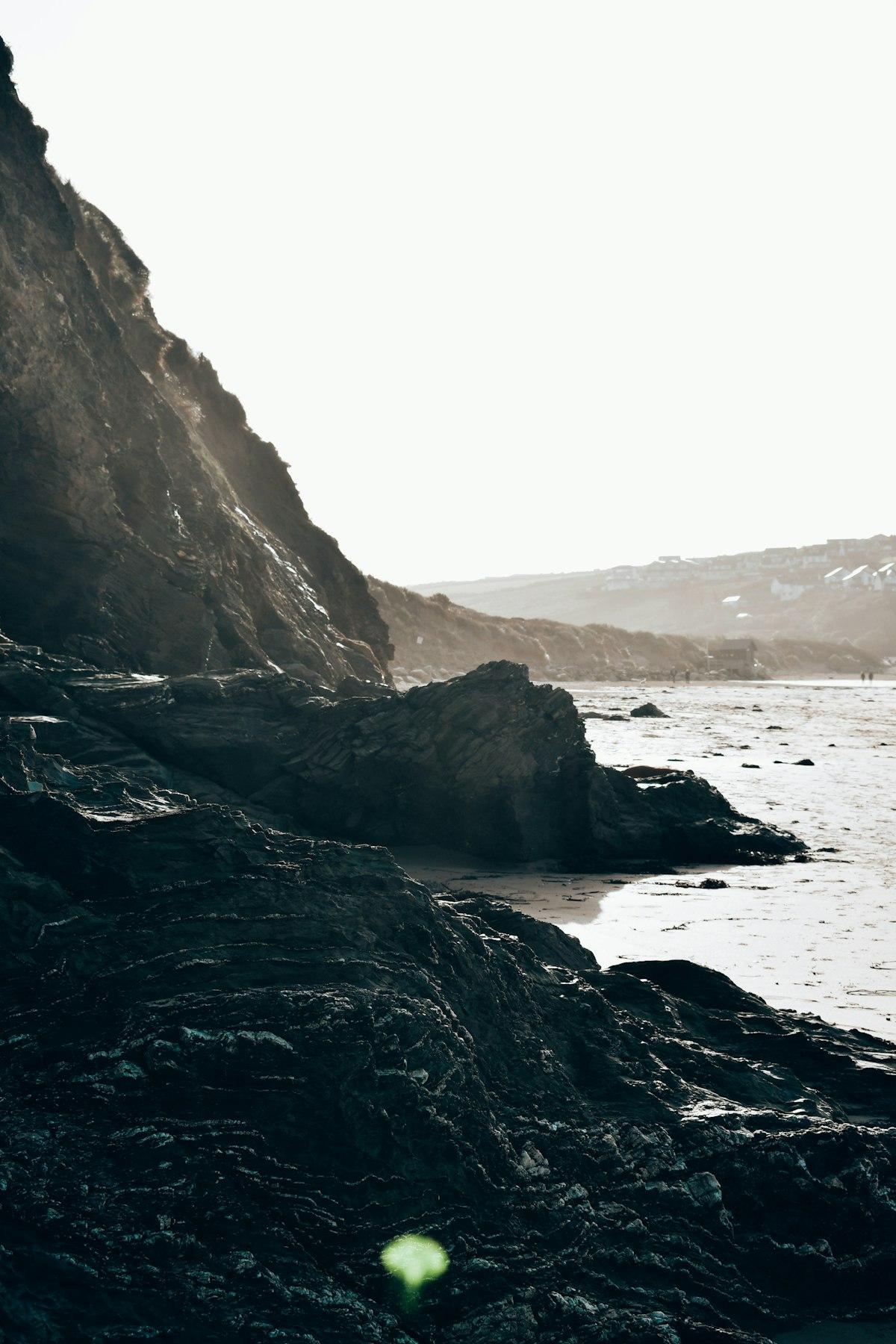 Person contemplating on rocky Cornwall beach
